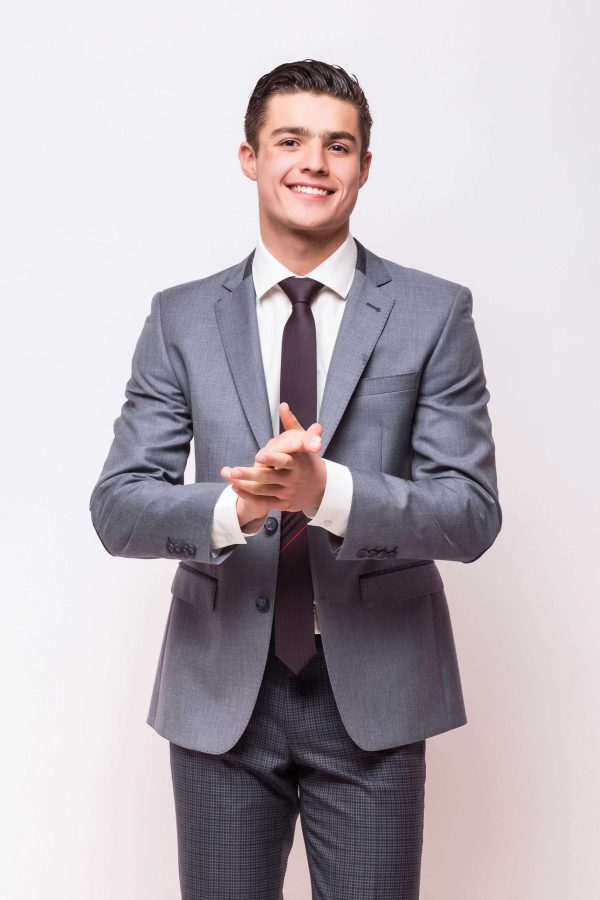 Happy business man wearing grey suit standing and folding arms